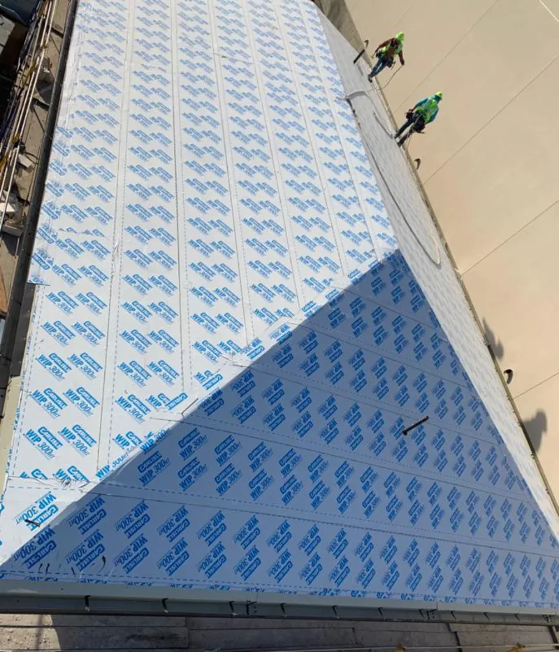 Professional roofers installing underlayment on a metal roof in West Carrollton